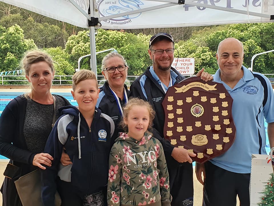 A family group at Epping holding a large wooden honour shield.