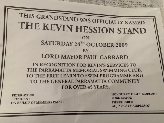 Printed notice: This grandstand was officially named The Kevin Hession Stand on Saturday 24 October 2009 by Lord Mayor Paul Garrard, in recognition of Kevin’s services to the Parramatta Memorial Swimming Club, the free learn-to-swim programme and the Parramatta community for over 45 years.